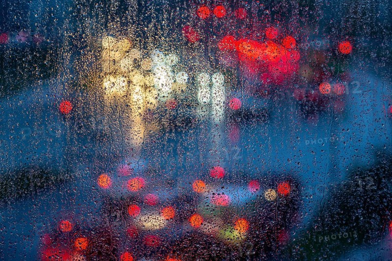 Rainy weather, road traffic, raindrops on a window pane, behind, blurred, lights of vehicles on a rain-soaked road, traffic light, tail lights, headlights, symbolic image