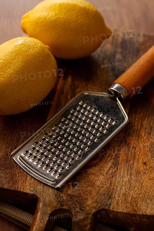 Lemons with a zest grater, on a chopping board, close-up, no people