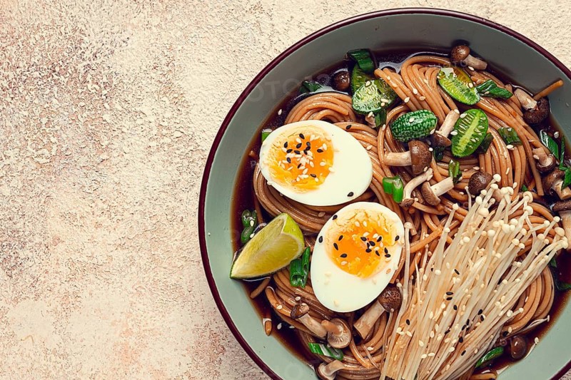 Soba, buckwheat noodles, with enoki mushrooms, shimeji and boiled egg, top view, homemade, no people
