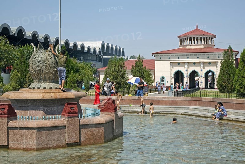 Children playing in fountain in front of the Chorsu Bazaar in the center of the old town of Tashkent, capital city of Uzbekistan