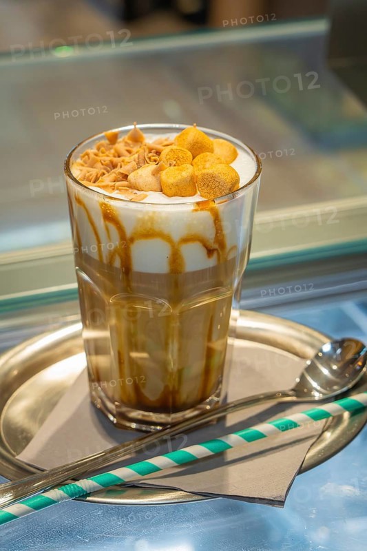 A glass of iced coffee with cream and caramel on a tray, served with a straw and spoon, autumn creations, Cafe Kuh, Deckenpfronn, Black Forest, Germany, Europe