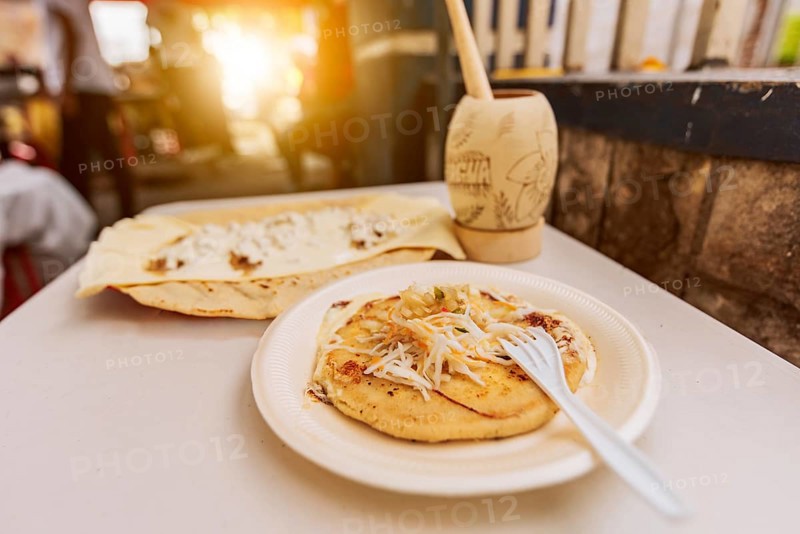 Traditional pupusa with Quesillo served on the table. Quesillo with pupusa served on the table with traditional cocoa drink