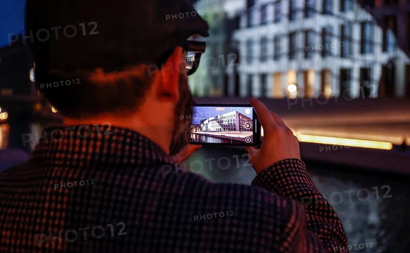 A man takes a photo of the Humboldt Forum with a smartphone during the Festival of Lights, Berlin, 07.10.2024, Berlin, Berlin, Germany, Europe