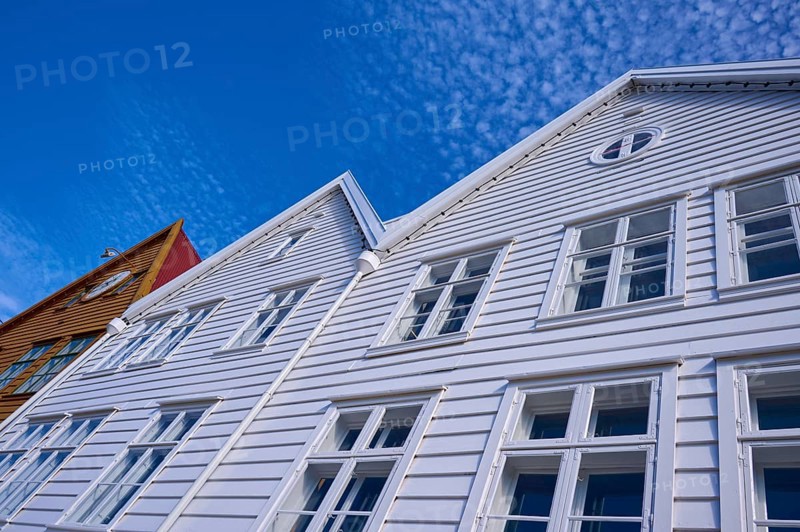 Traditional wooden houses under a blue sky with pitched roofs and multiple windows in a sunny old town, Bryggen, Bergen, Vestland, Norway, Europe