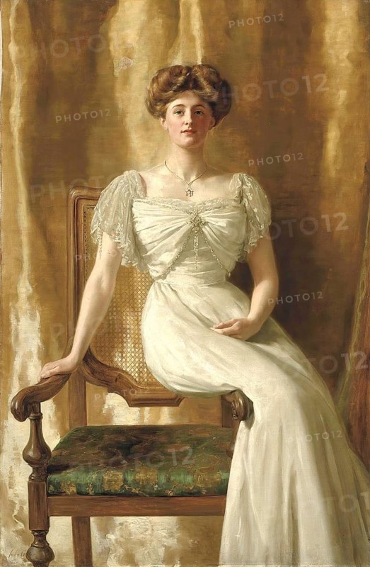 A woman in an ivory-coloured dress sits on an ornate chair against a golden background. portrait of Mrs Harold Ritchie, Portrait of Mrs Harold Ritchie, Painting by John Maler Collier (28 January 1850, 11 April 1934), British writer and painter, Historic, digitally restored reproduction from a 19th century original, Record date not stated