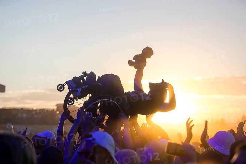 A wheelchair user crowdsurfing in front of sunset at the Highfield Festival on Friday, Störmthaler See, 16/08/2024