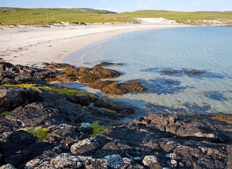 Rocky headland and sandy beach at Bagh a Deas, South Bay, Vatersay island, Barra, Outer Hebrides, Scotland, UK