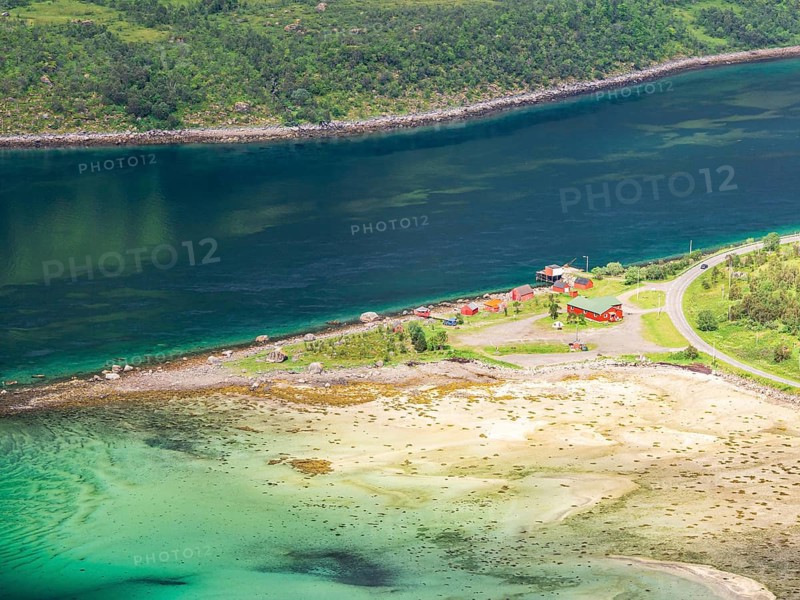 View from mountain range above village Raften down to shore at the Raftsund, the strait between islands Hinnøya and Austvågøya, glimps of sunshine on the campsite at the sandy shore, Norway, Europe