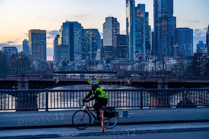 Skyline of the city centre of Frankfurt am Main, cyclist on the raft bridge, dusk, river Main, winter, Hesse, Germany, Europe