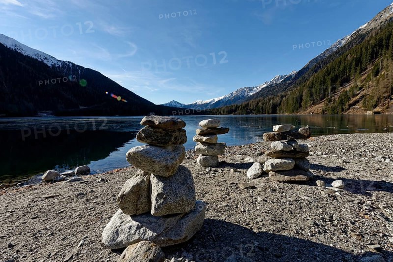 Cairns in winter on the icy lake, Lake Antholz in the Antholz Valley, Val Pusteria, South Tyrol, Italy, Europe