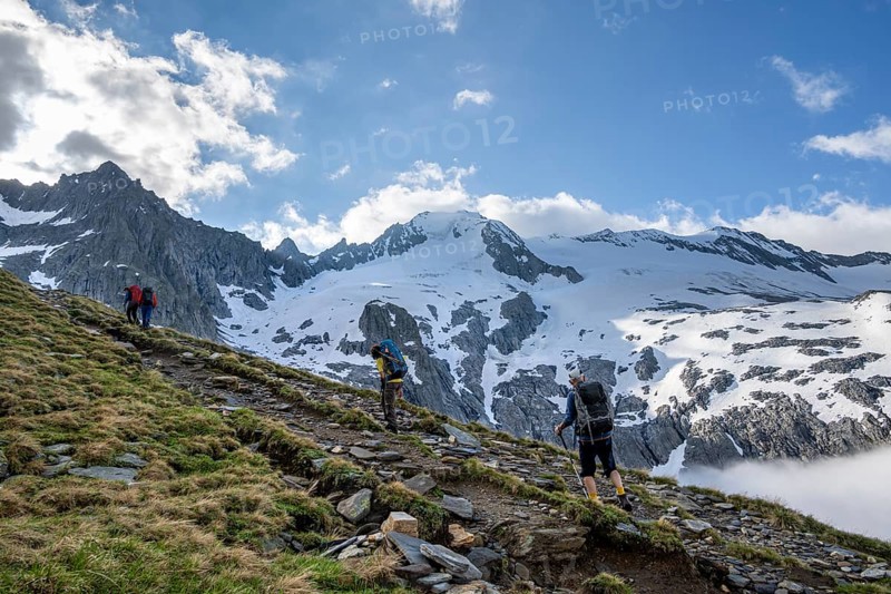 Mountaineers on a hiking trail, high fog in the valley, glaciated mountains with Furtschagelkees, summit Großer Möseler and Furtschaglspitze, Berliner Höhenweg, Zillertal Alps, Tyrol, Austria, Europe