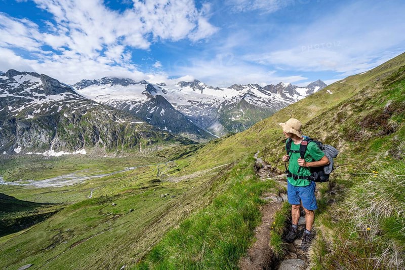 Mountaineer on hiking trail in picturesque mountain landscape, mountain peak with snow and glacier Hornkees and Waxeggkees, summit Hornspitzen and Großer Möseler, Berliner Höhenweg, Zillertal Alps, Tyrol, Austria, Europe