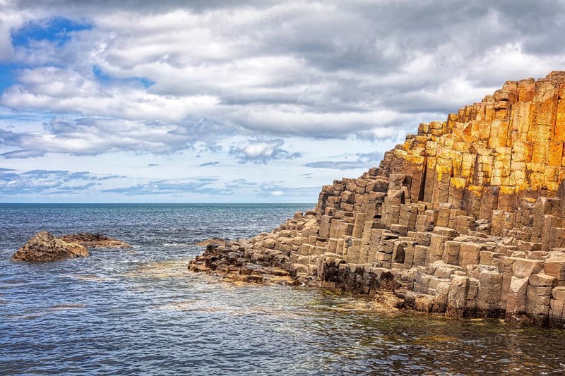 Rocks on the coastline with a view of the sea and cloudy sky, Giant Causeway