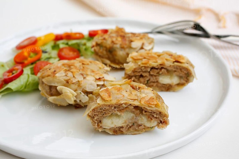 Swabian cuisine, meatballs wrapped in almonds, mixed minced meat, meatballs filled with cheese, fried, meatballs, grandmother's cooking, regional, home cooking, typical Swabian, traditional cuisine reinterpreted, served on a plate with salad, lettuce, cherry tomatoes, cocktail tomatoes, peppers, food photography, studio, Germany, Europe