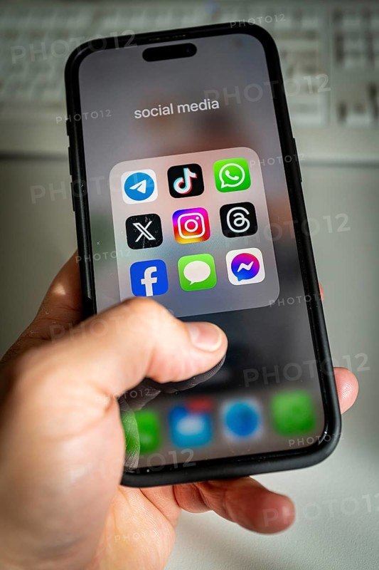 A smartphone shows various social media apps, threads, tik tok, Telegram & co on the screen