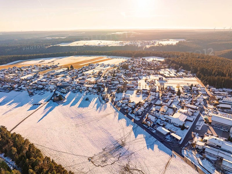 Snowy village in the evening light with extensive fields and neighbouring forest, cast shadows, Simmersfeld, district of Calw, Black Forest, Germany, Europe