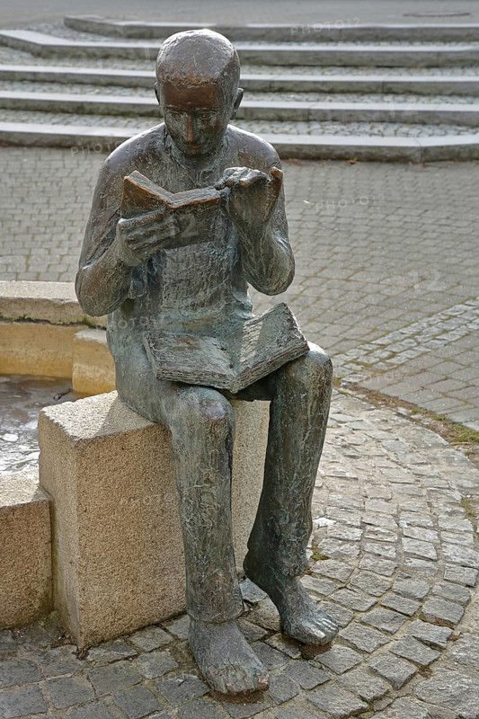Sculpture Book reader at the fountain in front of the town library, reader, literature, books, book, reading, head, figure, book, holding, hand, bronze sculpture, Pfleghof, Langenau, Alb-Donau-Kreis, Swabian Alb, Baden-Württemberg, Germany, Europe