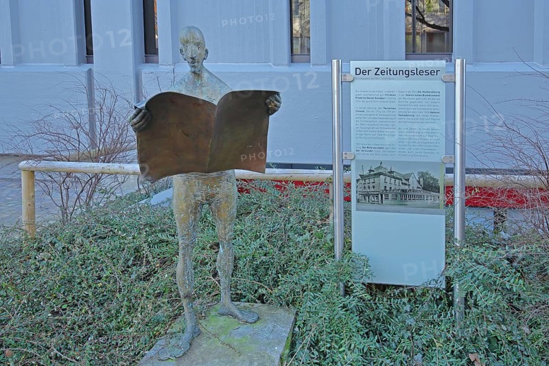 Sculpture Newspaper Reader by Karl Ulrich Nuss 2005 with historical text, inscription, bronze sculpture, male figure reading a newspaper, standing, reader, literature, market square, Aalen, Swabian Alb, Baden-Württemberg, Germany, Europe