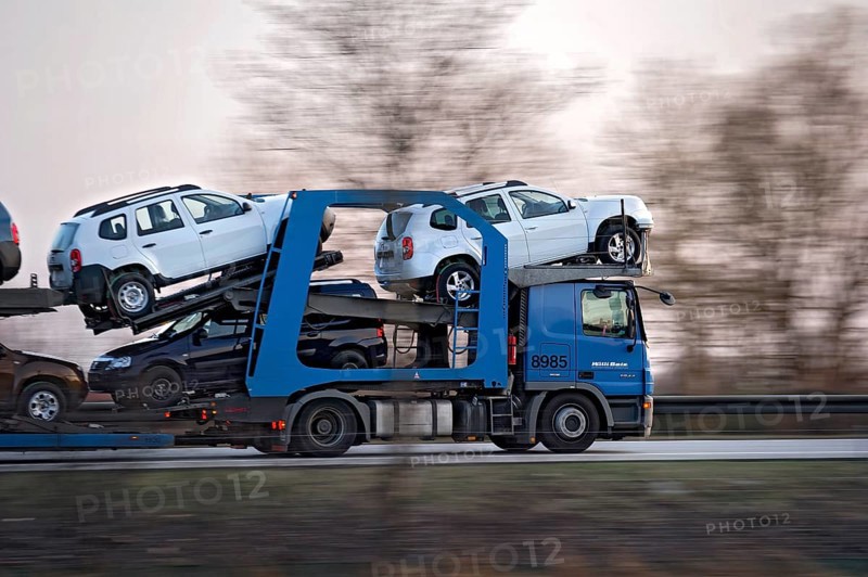 Truck, lorry, articulated lorry with new Dacia cars driving fast on the A92 motorway, motion blur, wiping effect, Freising, Upper Bavaria, Bavaria, Germany, Europe