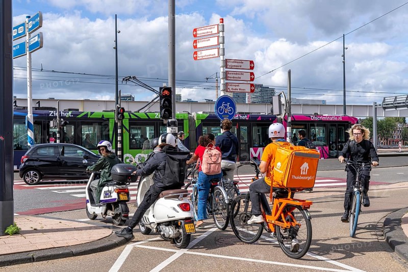 Cyclist, moped rider, waiting at a red traffic light, Feijenoord, in front of the Erasmus Bridge, Rotterdam, Netherlands