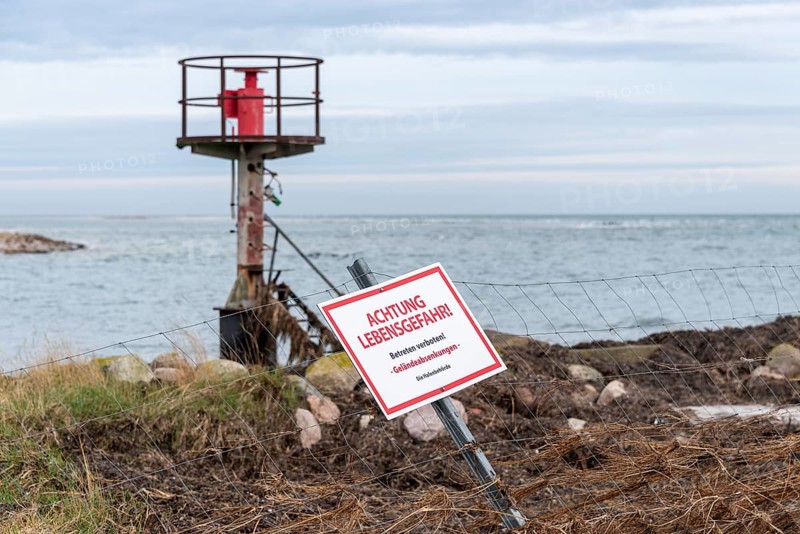 Beacon behind a fence with warning sign 'ACHTUNG LEBENSGEFAHR', cloudy sky over the sea, entrance to the former emergency harbour Darßer Ort, Prerow, Mecklenburg-Western Pomerania, Germany, Europe