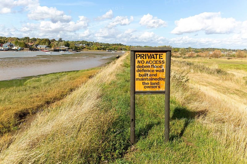 Private No Access sign of River Deben flood defence wall, Suffolk, England, UK view upstream towards Melton