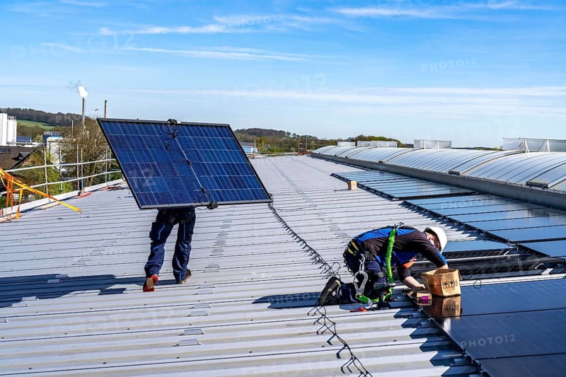 Installation of solar modules on the roof of a commercial enterprise, over 400 photovoltaic modules are installed on the roof, North Rhine-Westphalia, Germany, Europe