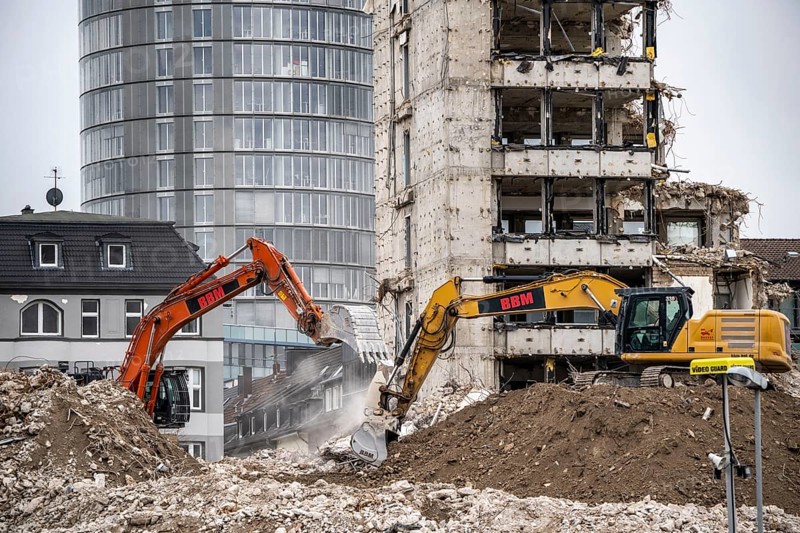 Demolition of the former RWE building complex, in the city centre, on the A40 motorway in Essen, excavator working on the piles of rubble, in the background the RWE Tower, North Rhine-Westphalia, Germany, Europe
