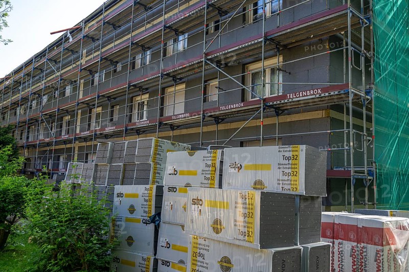 Energetic renovation of an apartment building, thermal insulation, building materials, insulation materials stored in front of the construction site, scaffolded building