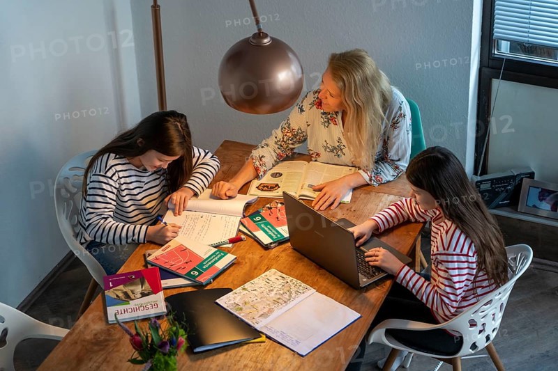 Homeschooling, during the lockdown in January 2021, mother helps her two daughters, at home, learning, a girl is in video lessons with her class, school closures, distance learning, effects of the corona crisis in Germany