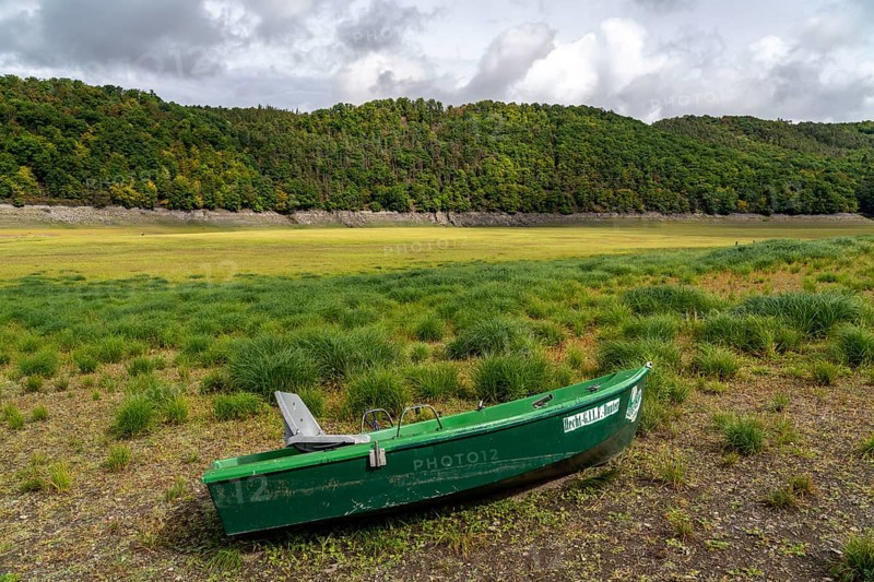 The Edersee, near Waldeck, the third largest reservoir in Germany, currently has only just under 13% of its normal level, the lake was last full in May 2022, dried up due to lack of rain, stranded fishing boat, pike hunter, the lake shore and the lake bottom is overgrown with fresh grass, Hesse, Germany, Europe