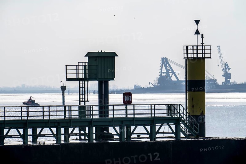 Weser estuary near Bremerhaven, view over the pier of the Freilaufkanal, across the Weser to the other bank near Nordenham, cranes of Steelwind Nordenham, which produce foundations for offshore turbines, Bremen, Germany, Europe