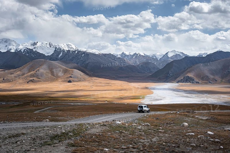 Off-road vehicle on a gravel track, glaciated and snow-covered peaks, Ak Shyrak Mountains, near Kumtor, Kara-Say, Tian Shan, Kyrgyzstan, Asia