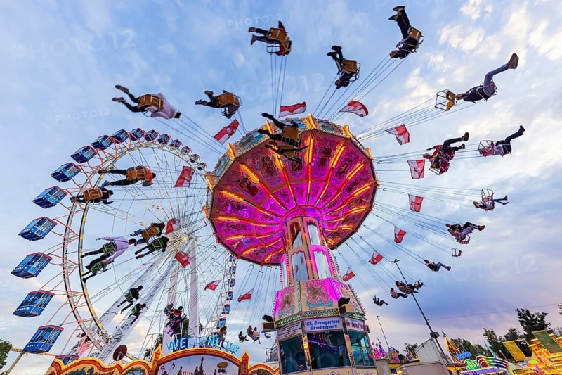 Chain carousel and Ferris wheel in the evening. 177th Cannstatter Volksfest at the Cannstatter Wasen. Bad Cannstatt, Stuttgart, Baden-Württemberg, Germany, Europe