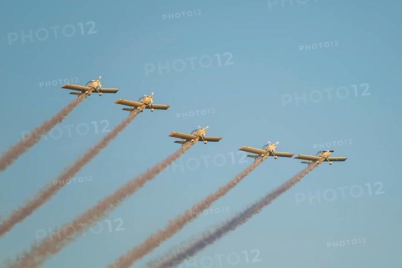 Stunt aerobatic planes performing stunts in blue sky with smoke trail. Concept of teamwork, collaboration, coordination, trust, precision, difficulty, challenge, speed, synergy