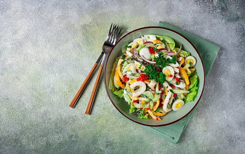 Salad with squid, fresh cucumber, eggs, sweet pepper, red onion, with dressing, homemade, no people