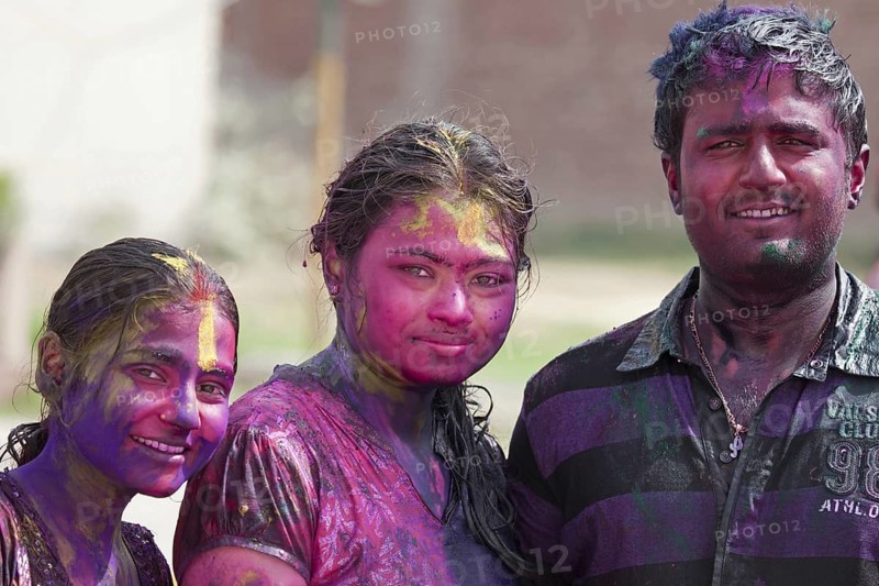 Teenagers covered in colourful dye celebrating the Holi festival, Festival of Colours in Mathura, Uttar Pradesh, India, Asia