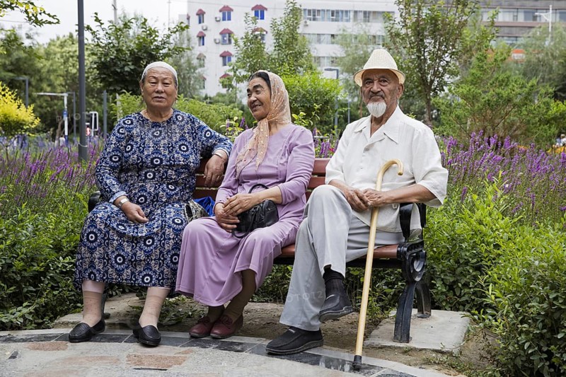 Three elderly Uyghurs sitting on a park bench in the city Hami, Kumul, one of China's ethnic minorities, Xinjiang, China, one of China's ethnic minorities, Xinjiang, China, Asia
