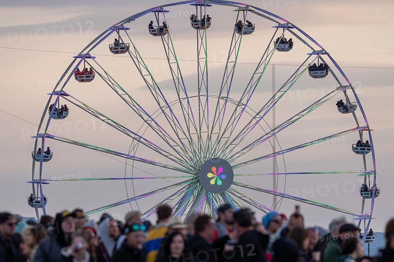 Adenau, Germany, 8 June 2024: Fans and Ferris wheel in the evening mood at the Rock am Ring Festival. The festival takes place at the Nürburgring race track near the town of Adenau from 7 to 9 June 2024, Europe