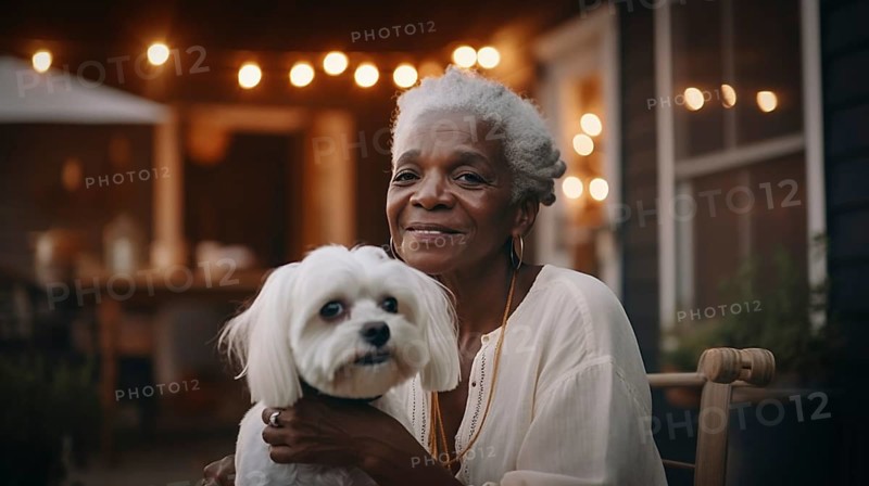 Attractive happy african american elderly woman on her porch holding her maltese puppy, generative AI, AI generated