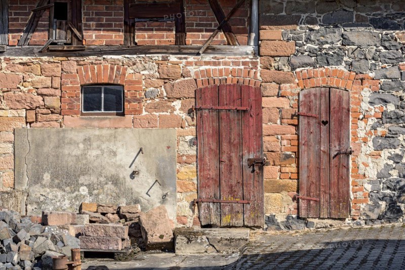 Historic farmhouse around 1800, half-timbered façade, sandstone, natural stone, brick, cement, weathered wooden doors to stable and loo, with heart, idyllic, romantic, Nidda, Vogelsberg, Wetterau, Hesse, Germany, Europe