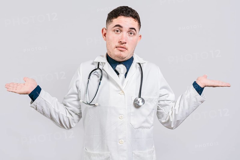 Puzzled doctor with open hands. Doubtful young doctor with open hands isolated. Insecure doctor concept isolated