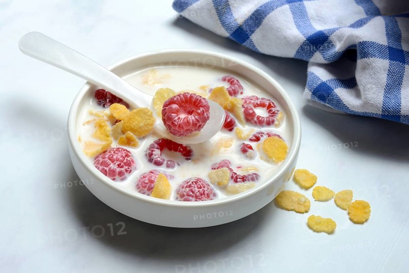 Raspberries and cornflakes with milk in a bowl, Rubus idaeus