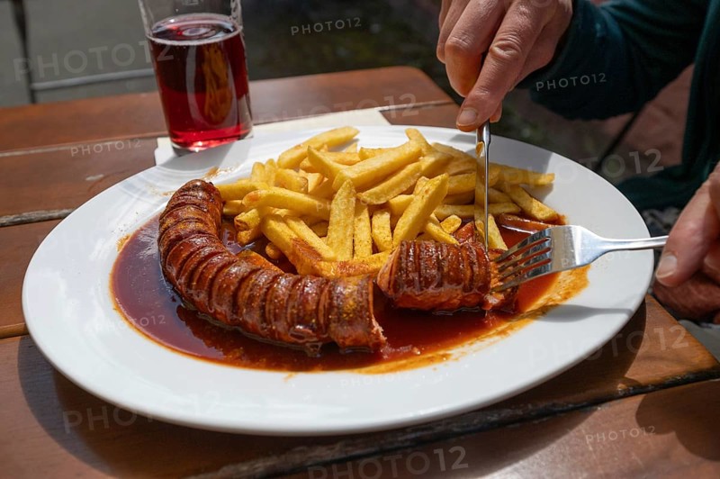 Currywurst with French fries served in a garden withe, Bavaria, Germany, Europe