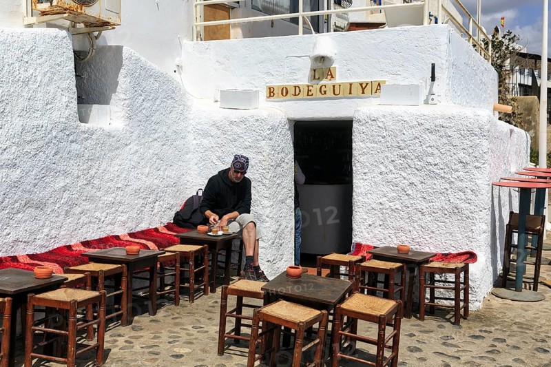 Tourist sitting at simple wooden tables outdoors, Bar La Bodeguiya, beach bar, Cabo de Gata Natural Park, Cabo-de-Gata-Nijar, Las Negras, Almeria, Andalusia, Spain, Europe