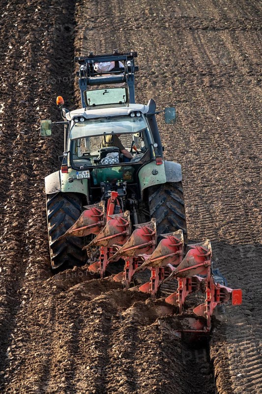 Farmer ploughing a field, tractor with plough, near Neuss, North Rhine-Westphalia, Germany, Europe