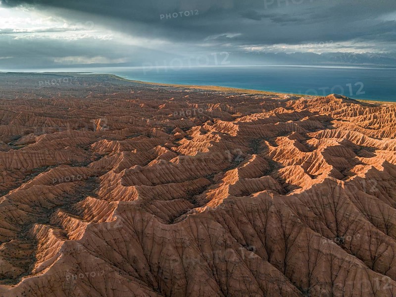 Landscape of eroded hills, badlands at sunset, Issyk Kul Lake in the background, aerial view, Canyon of the Forgotten Rivers, Issyk Kul, Kyrgyzstan, Asia