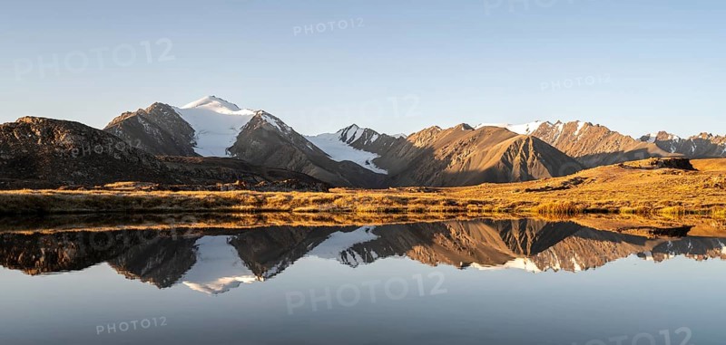 Glaciated mountain peaks reflected in a mountain lake at sunset, Arabel Lake at Arabel Pass, Issyk Kul Province, Kyrgyzstan, Asia