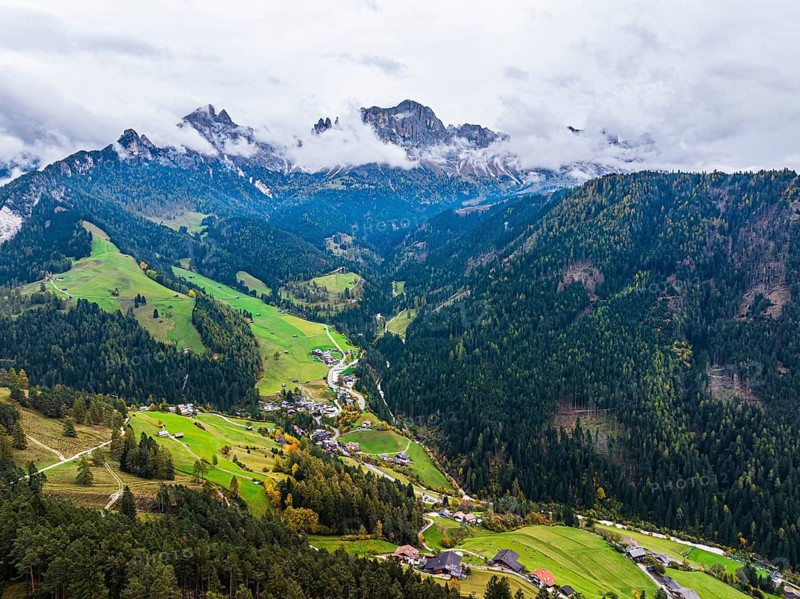 The village of Tiers, in the background the peaks of the rose garden, shrouded in mist, drone shot, Dolomites, Autonomous Province of Bolzano, South Tyrol, Italy, Europe