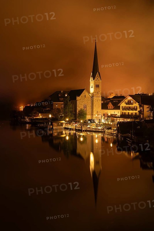 View of Hallstatt with the church and Lake Hallstatt at night. Clouds move through Hallstatt. Reflection. Hallstatt, Gmunden, Salzkammergut, Upper Austria, Austria, Europe